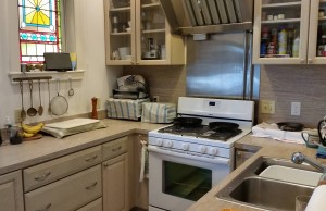 View of kitchen showing stovetop and stained glass window