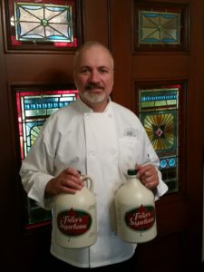 Chef Rob holding Two Gallons of Maple Syrup