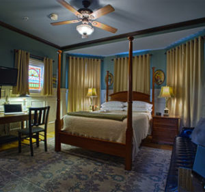 Room 205 showing antique poster bed and stained glass window