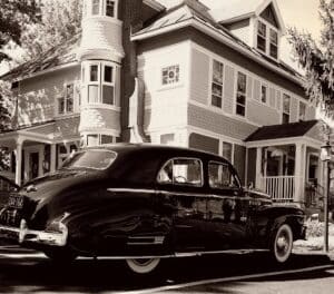B&W photo of inn with antique car